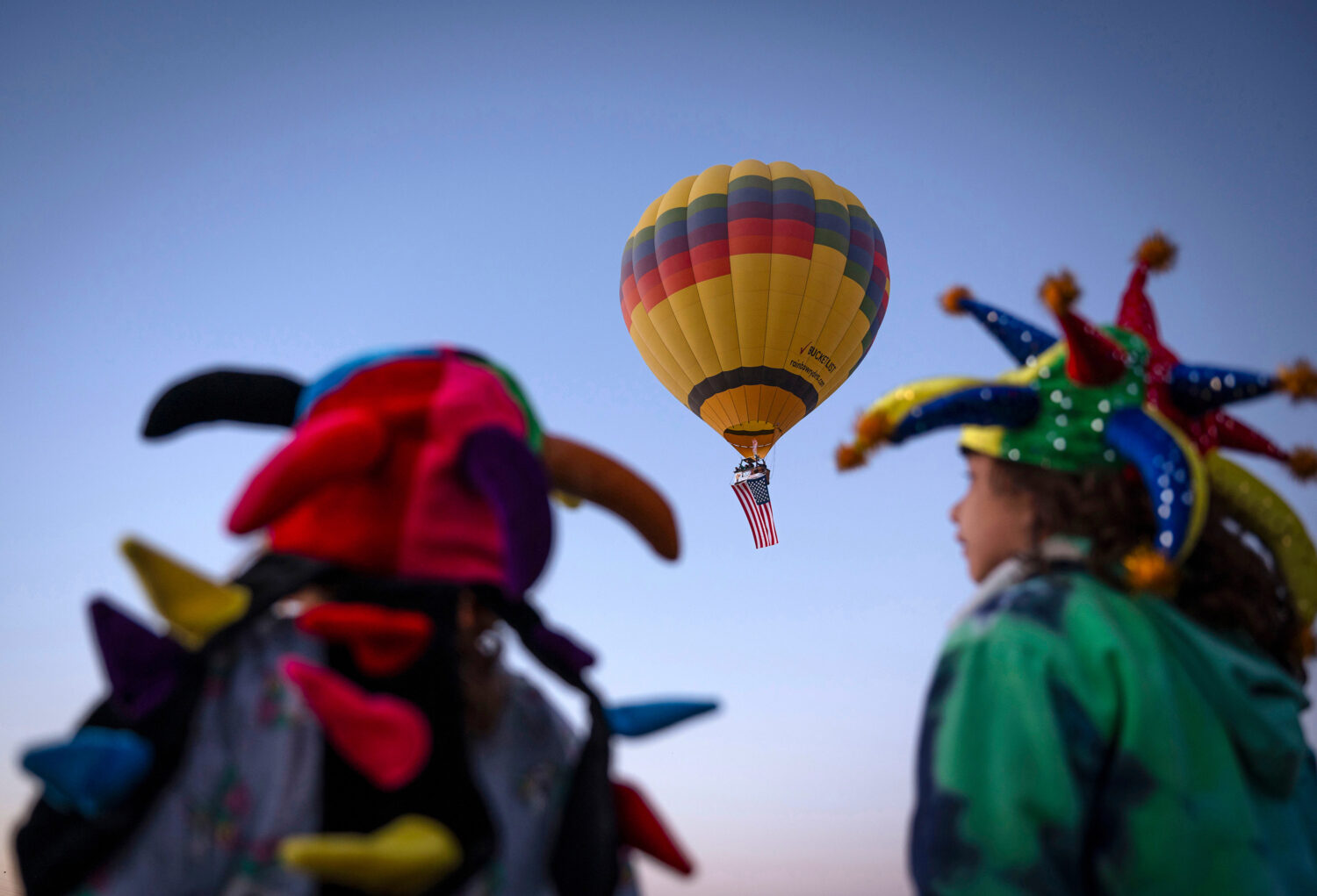 FILE - Cecilia Zike, 5, and Gianna Zike, 8, watch as a Rainbow Ryders' hot air balloon takes flight...