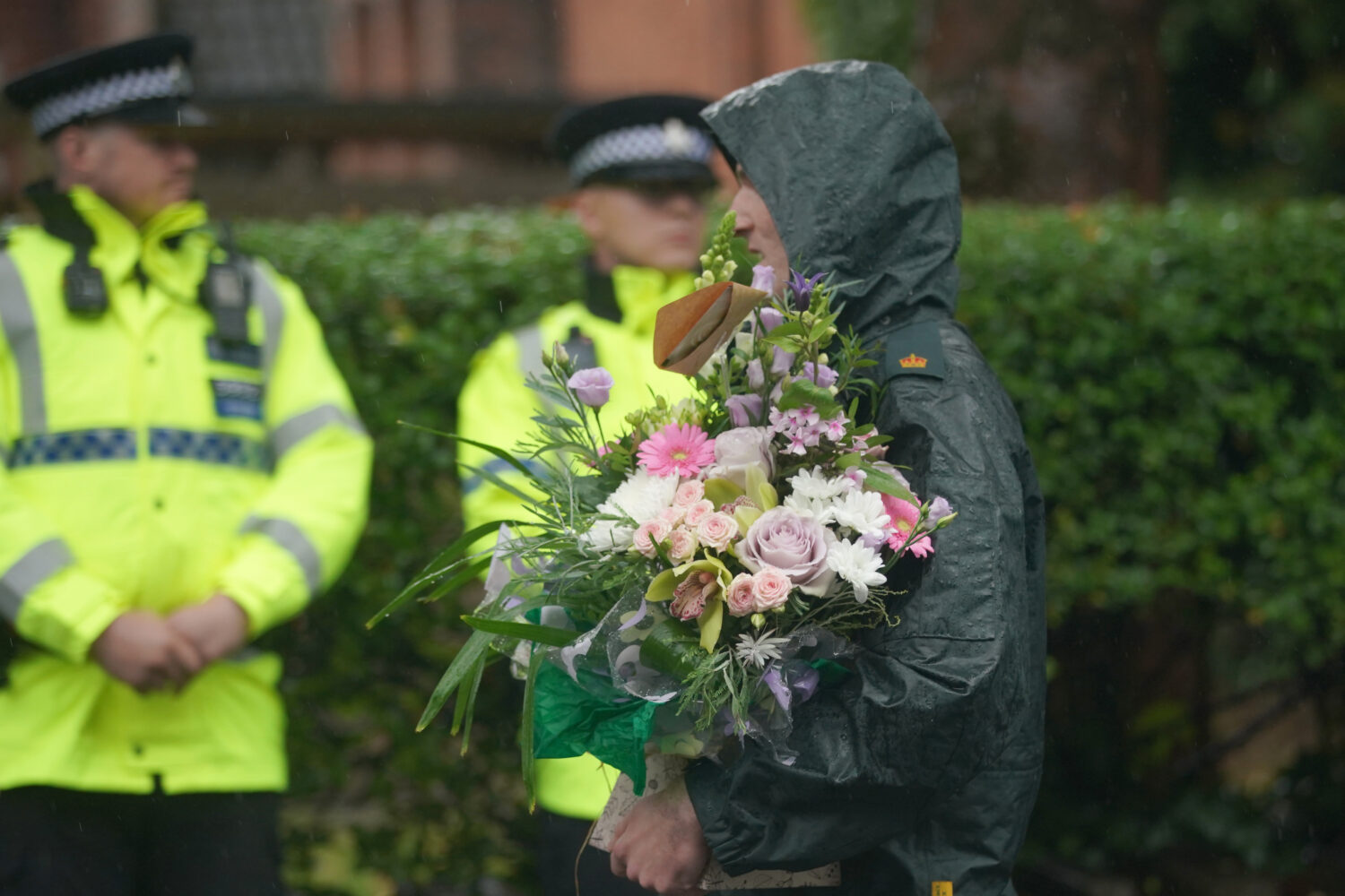 A woman brings flowers as she attends a vigil for the victims of the attack on the Heaton Park Hebr...