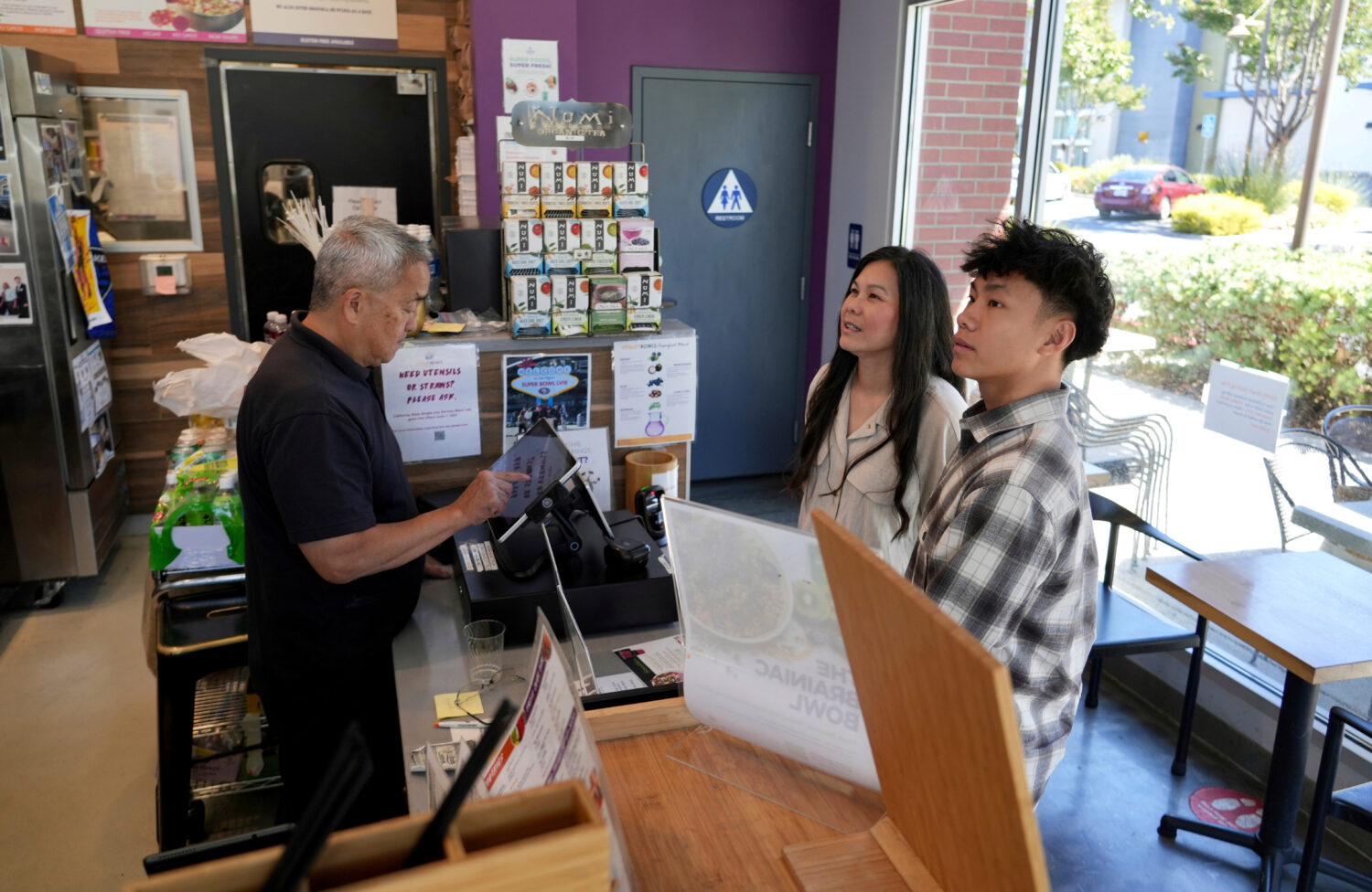 FILE - Braxton Kimura, right, orders food with his mother Carol Kimura at Vitality Bowl on Aug. 13,...