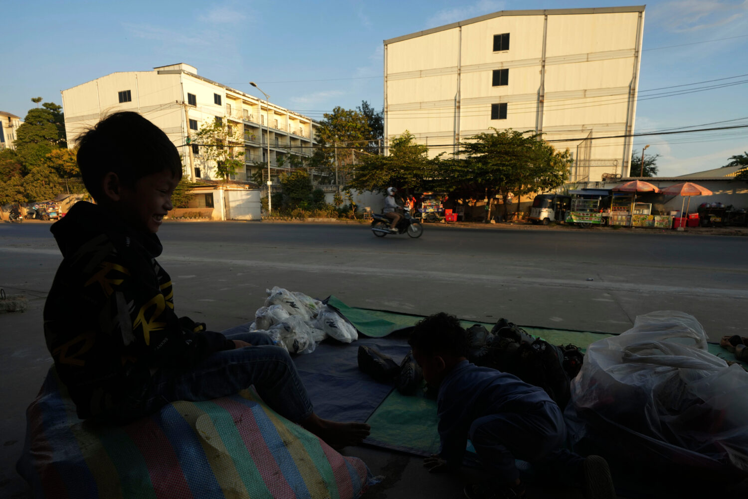 FILE - A boy plays near a building, where some people trafficked under false pretenses are being fo...
