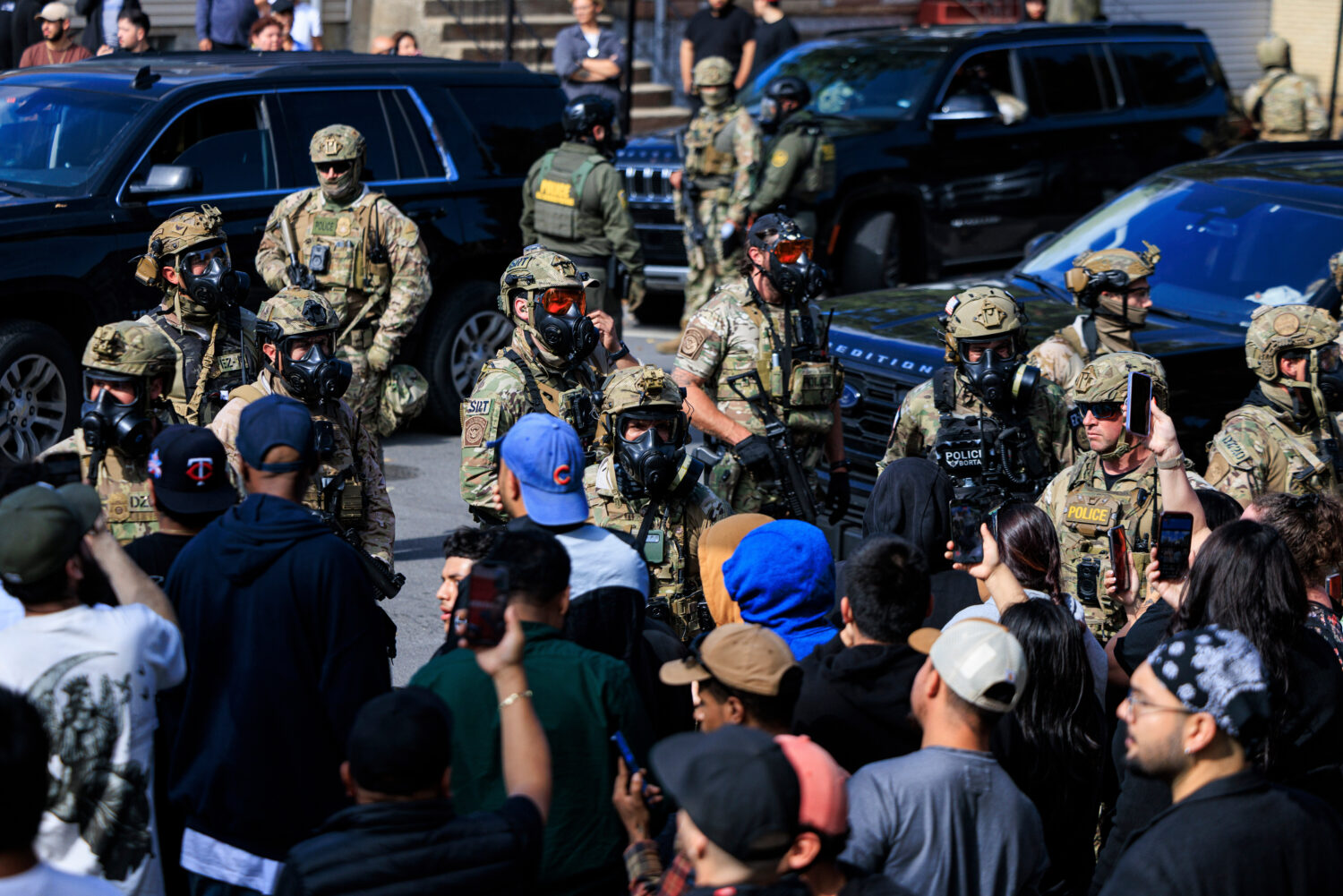 Government officials watch protesters gathering in Chicago, Tuesday, Oct. 14, 2025. (Anthony Vazque...