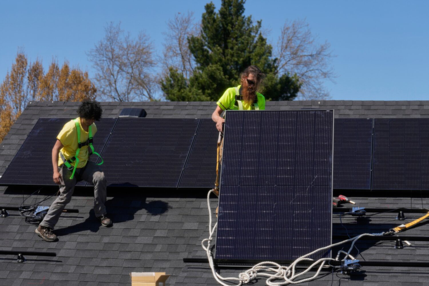 FILE - Brayan Santos, left, and Theodore Tanczuk, right, of solar installer YellowLite, put solar p...