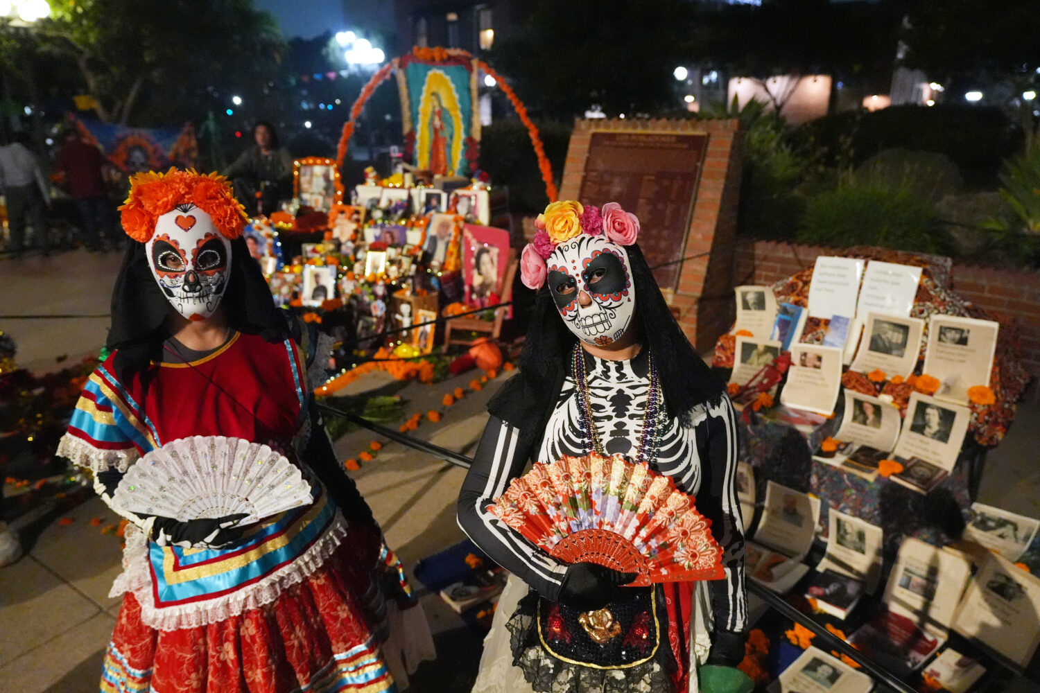 People join Olvera Street merchants in a night procession during the Day of the Death festival , Su...