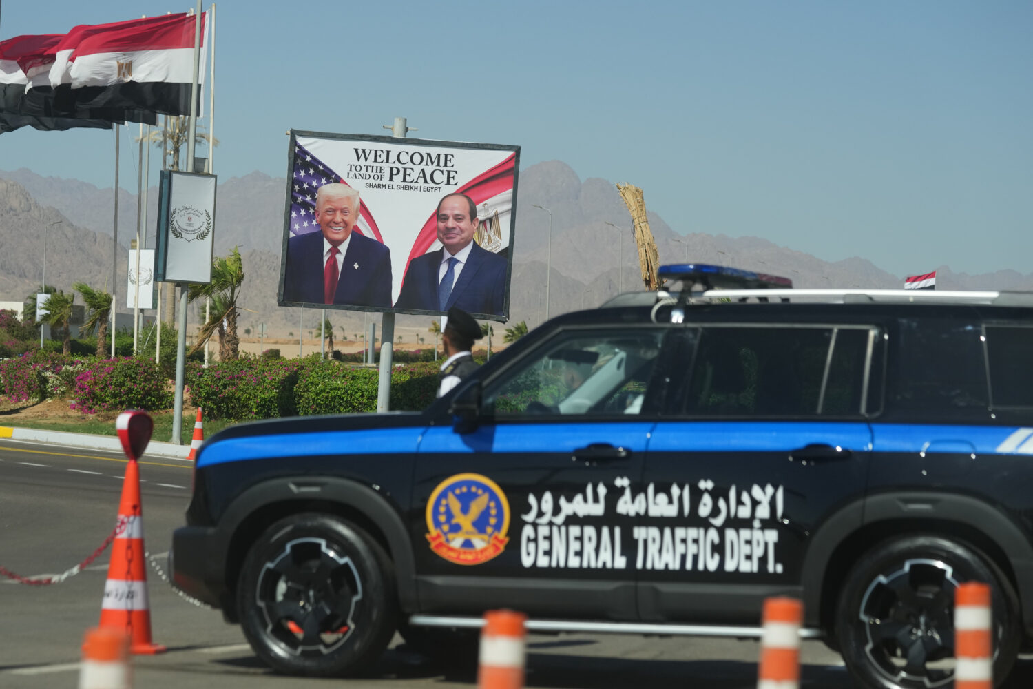 A police vehicle in front of a poster showing Egyptian President Abdel-Fattah el-Sissi and U.S. Pre...