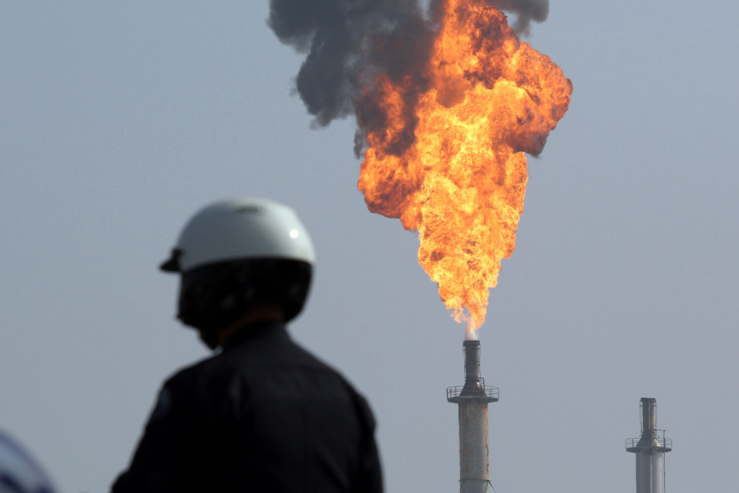 FILE - A very large smokestack flare burns off flammable product after an explosion in a processing...