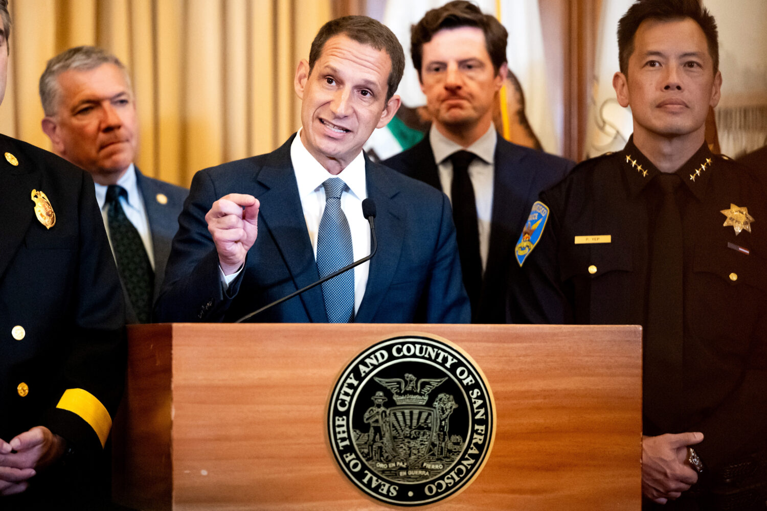 Flanked by city leaders, San Francisco Mayor Daniel Lurie discusses President Donald Trump's commen...