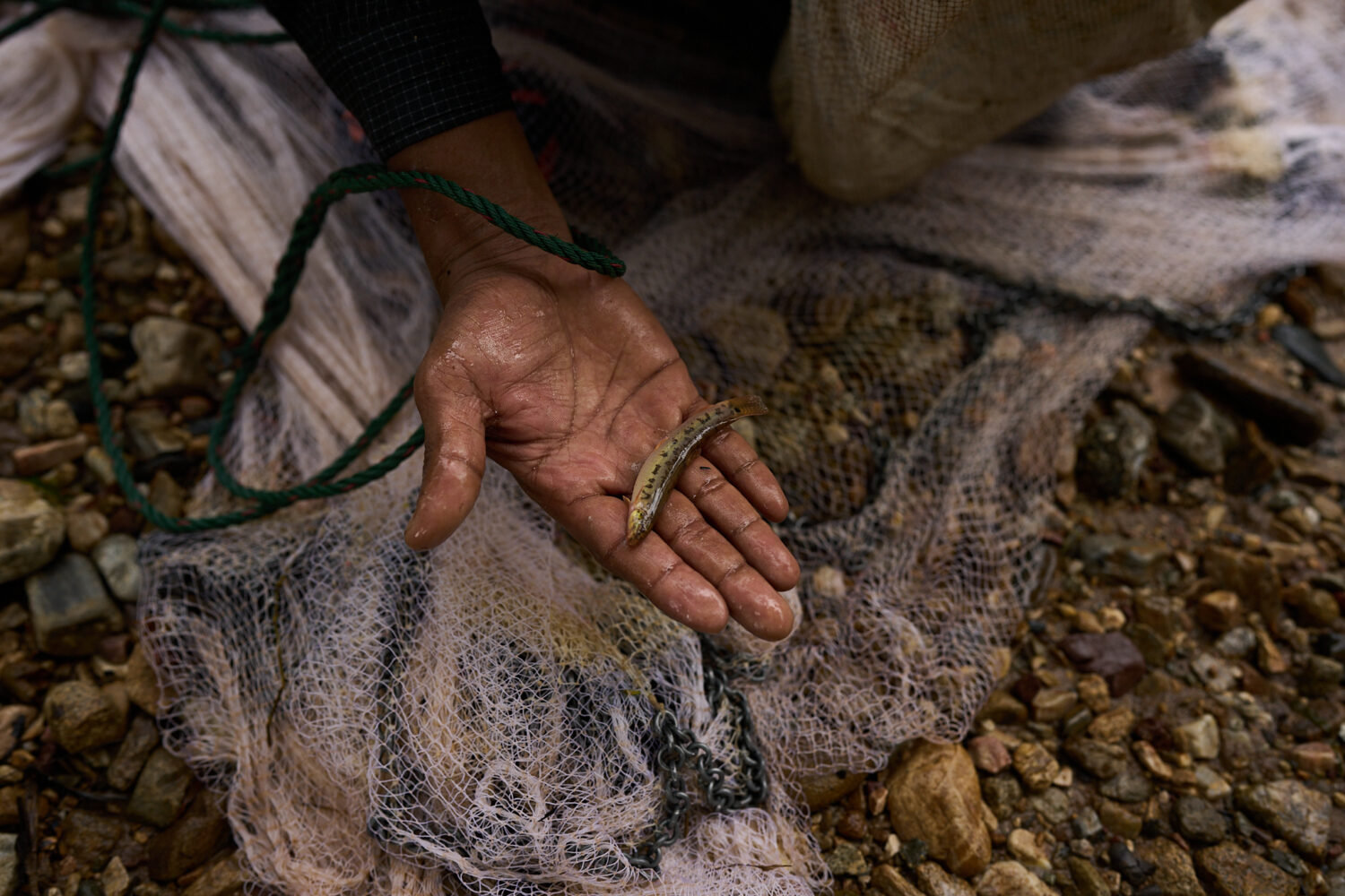 Mahmud Karmar holds a small fish he caught in the river near the Mae La refugee camp in the Tak pro...