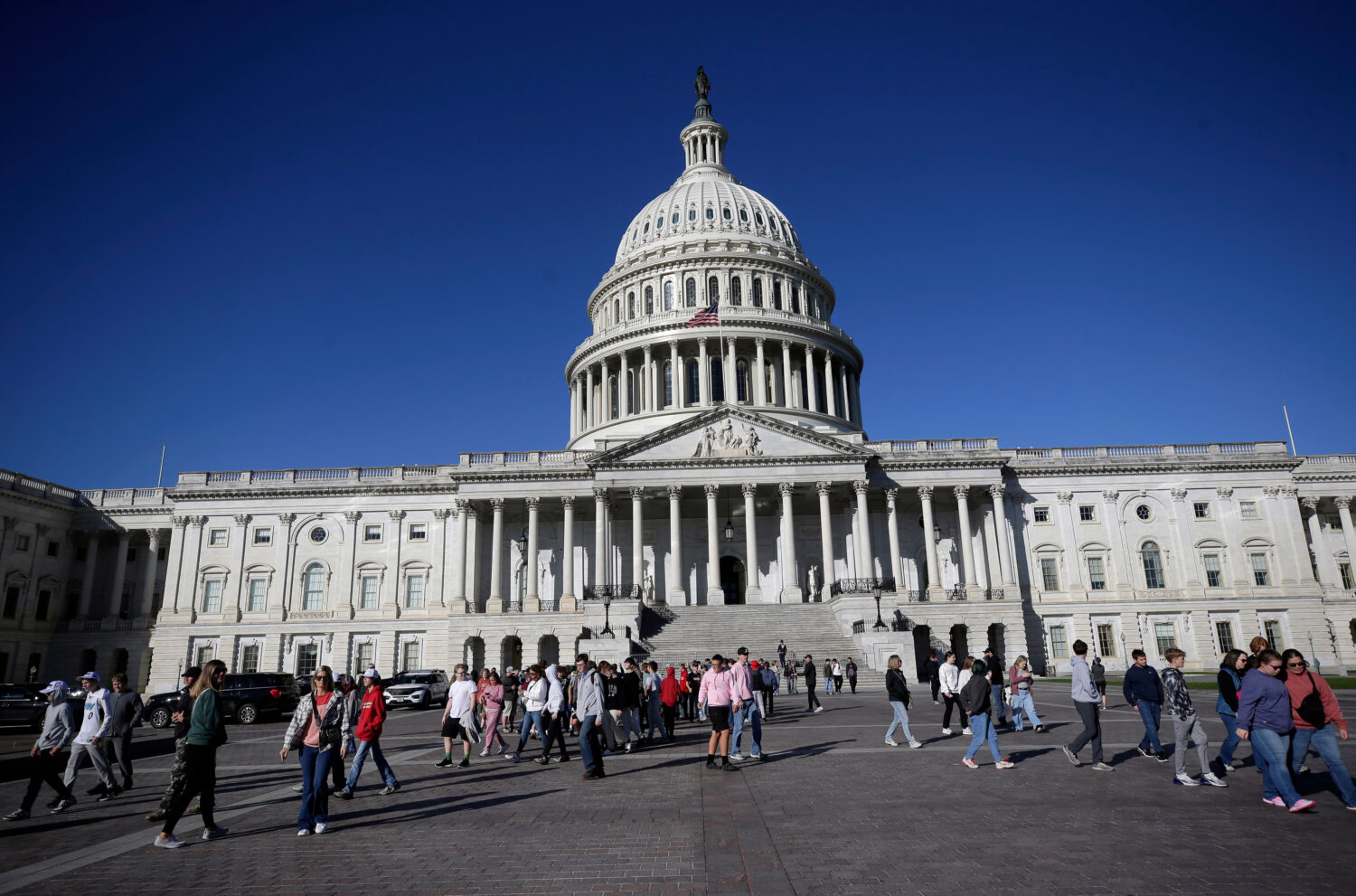 People walk on the East Front at the U.S. Capitol, Friday, Oct. 17, 2025, in Washington. (AP Photo/...