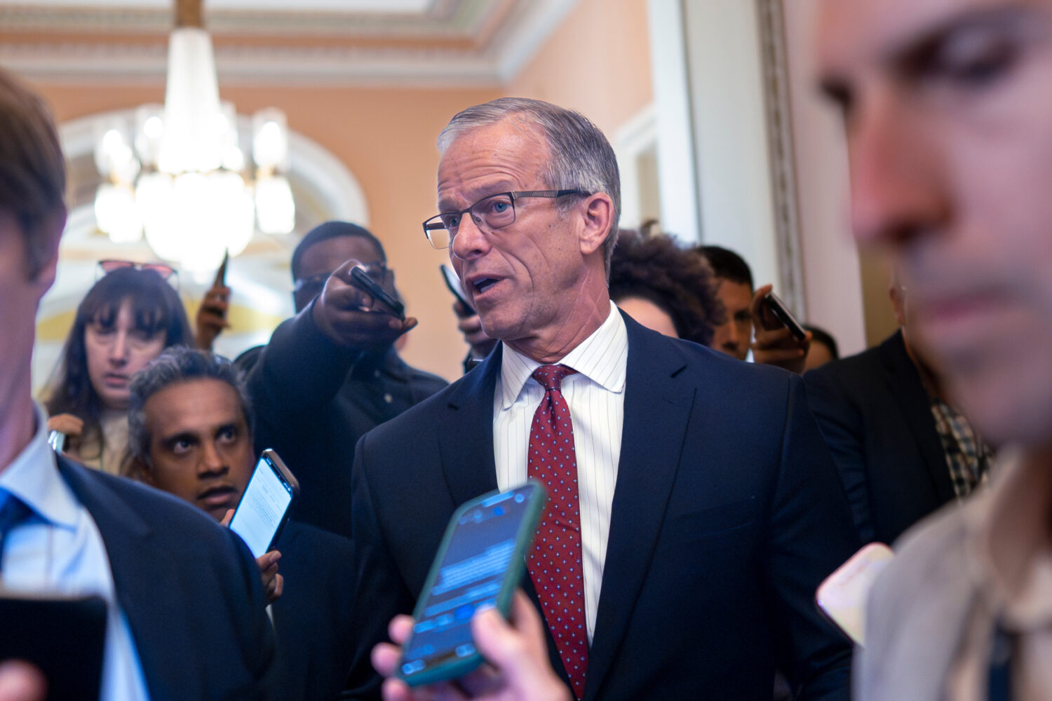 Senate Majority Leader John Thune, R-S.D., pauses in his office doorway to speak to reporters on da...