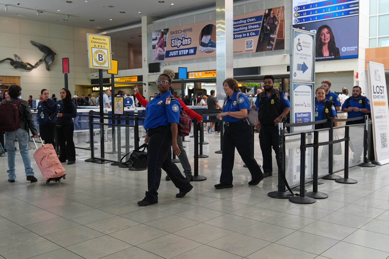 Transportation Security Administration employees leave a security checkpoint during a shift change ...