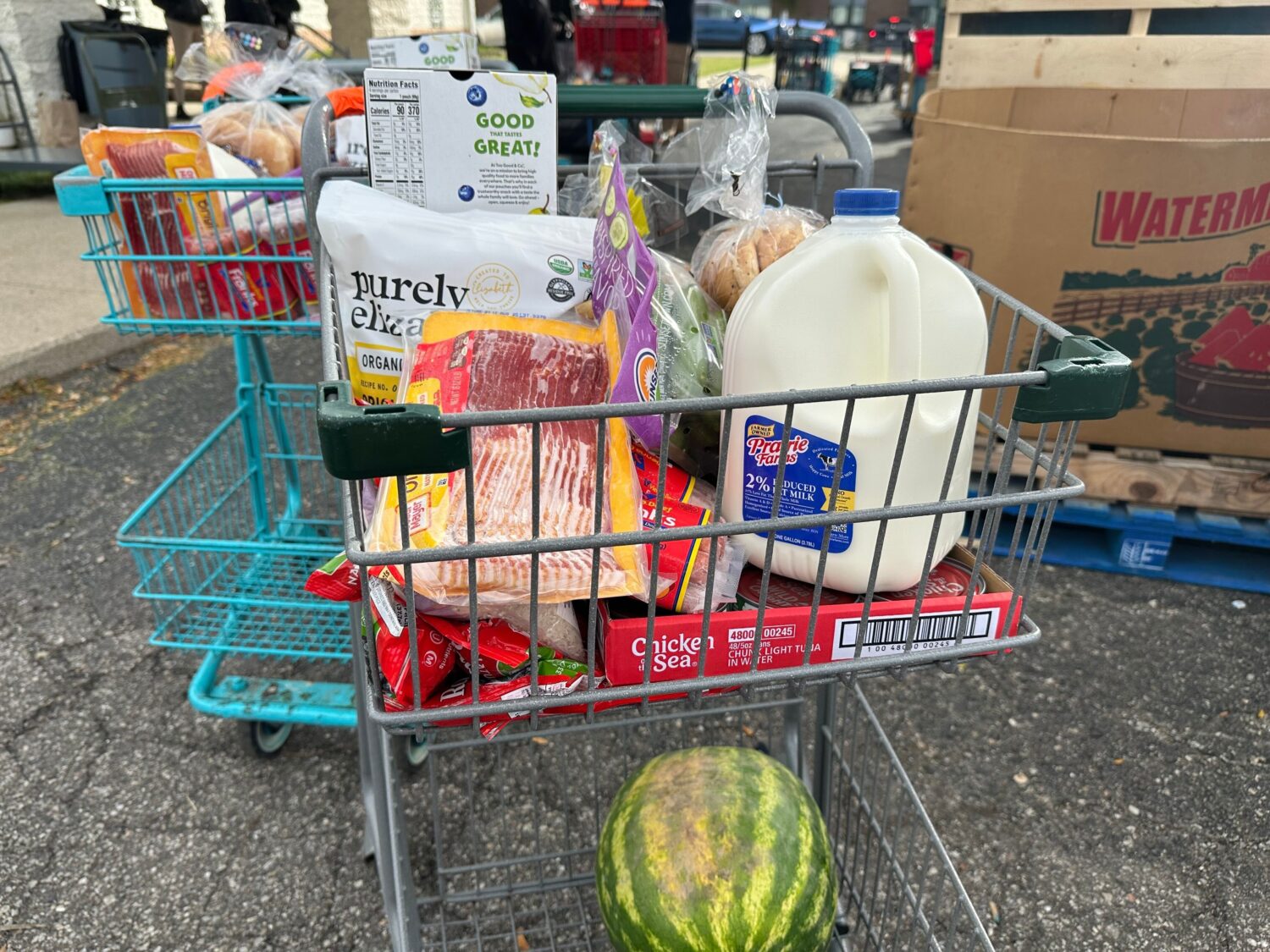 Food and milk sit in a shopping cart during a Forgotten Harvest distribution event held at Woodside...