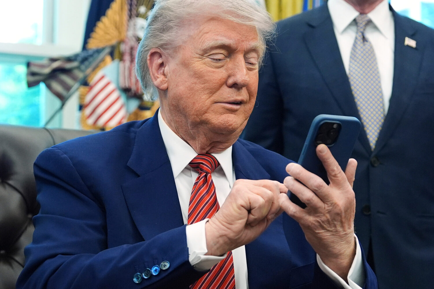 FILE - President Donald Trump silences his mobile phone in the Oval Office of the White House, May ...