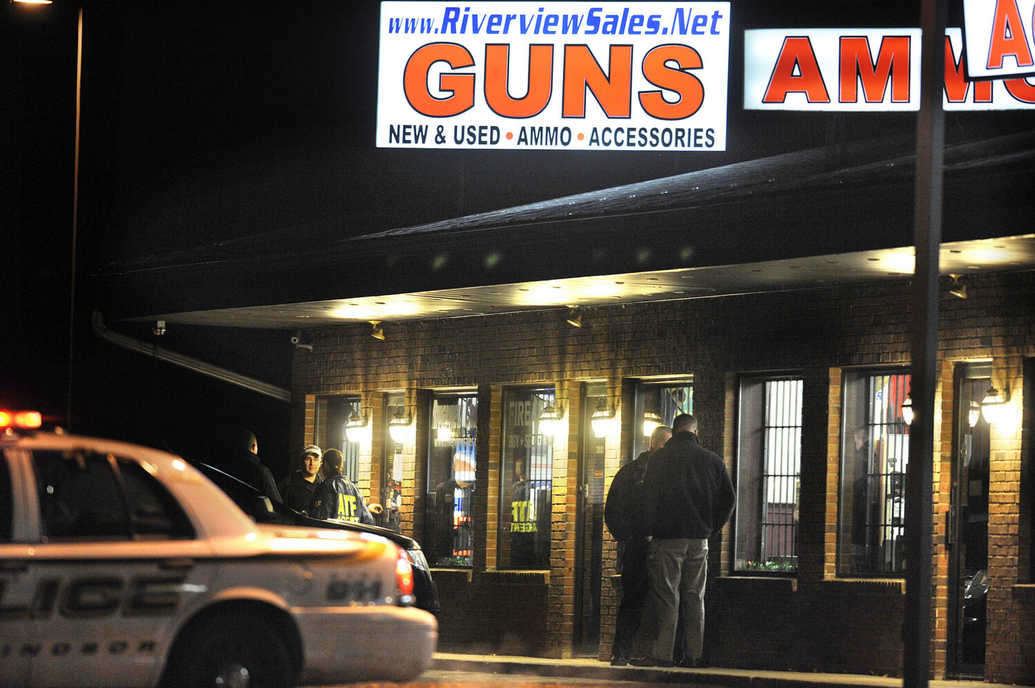 FILE - In this Dec. 20, 2012 file photo, law enforcement officials stand outside Riverview Gun Sale...