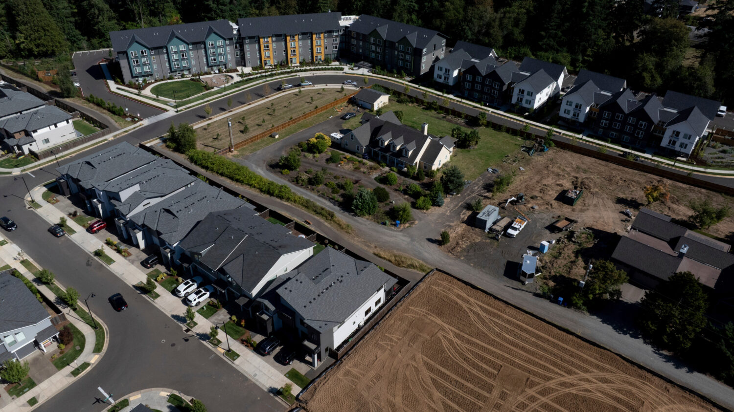 FILE - New construction homes and apartments are seen surrounding an older home on Friday, July 11,...