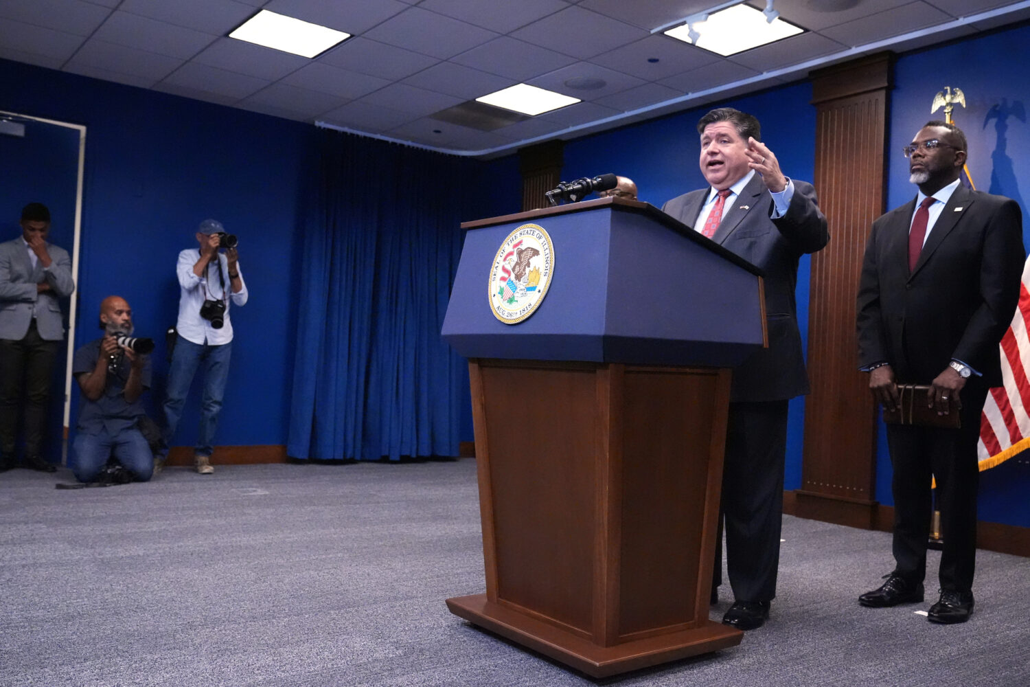 Governor JB Pritzker, second from right, speaks as Chicago Mayor Brandon Johnson, right, listens to...