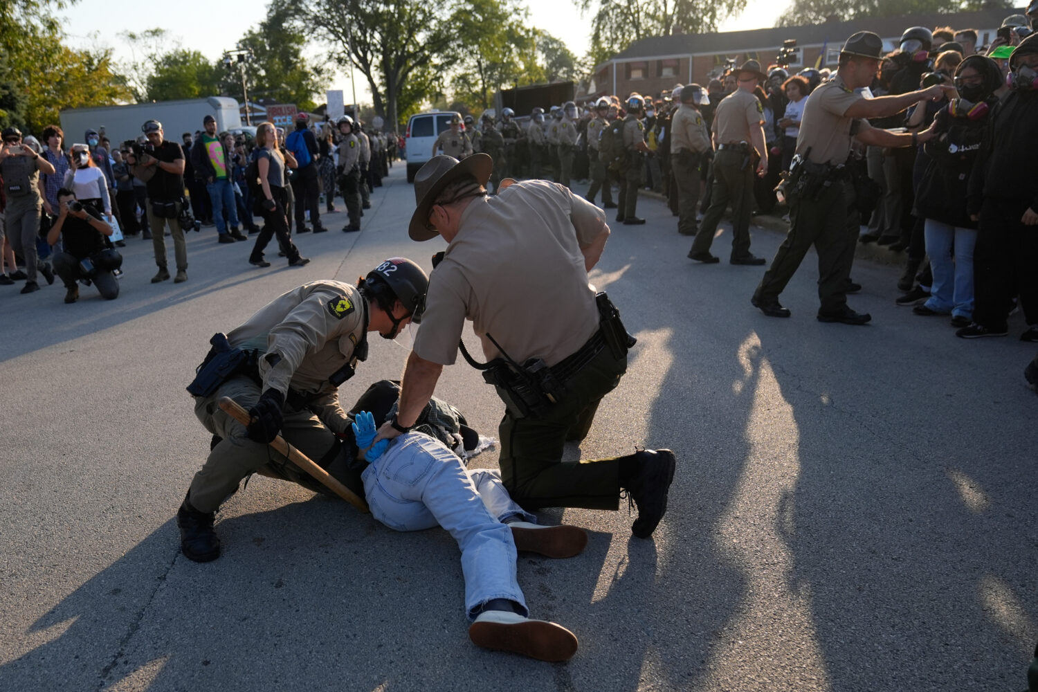 Law enforcement detains a protester near an Immigration and Customs Enforcement facility in Broadvi...