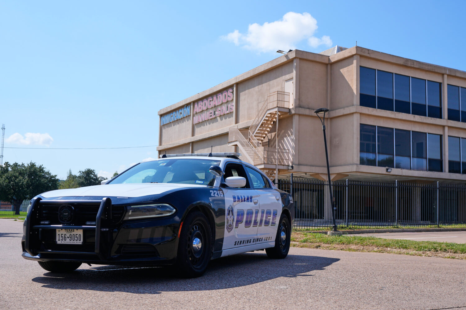 A Dallas police officer's vehicle blocks the road near a crime scene by a U.S. Immigration and Cust...