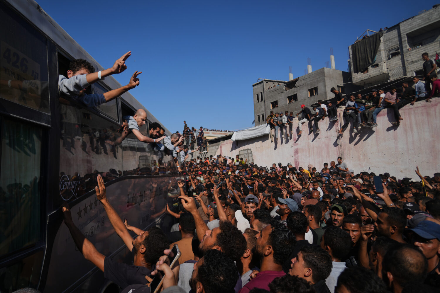 People gather to greet freed Palestinian prisoners arriving on buses in the Gaza Strip after their ...