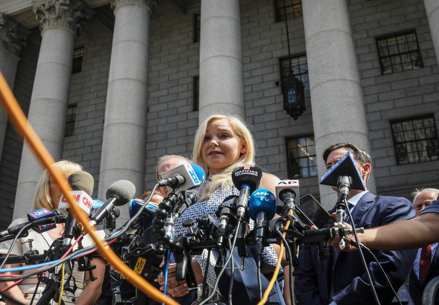 FILE - Virginia Roberts Giuffre, center, who says she was trafficked by sex offender Jeffrey Epstei...