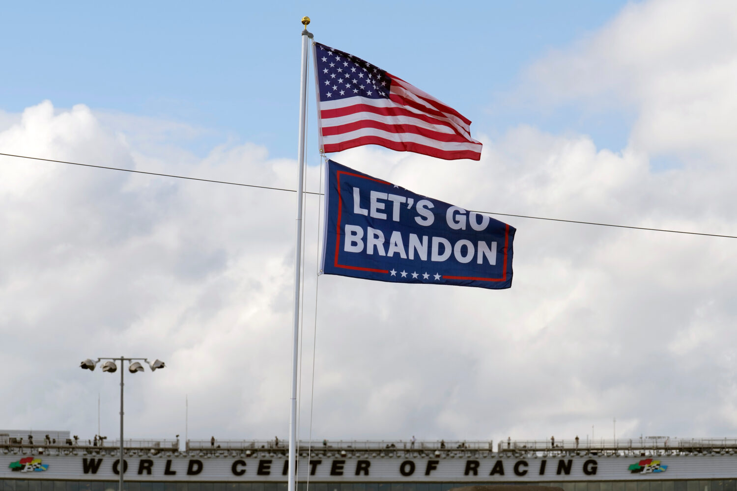 FILE - A "Let's go Brandon" flag flies below the American flag, Feb. 18, 2022, at Daytona Internati...