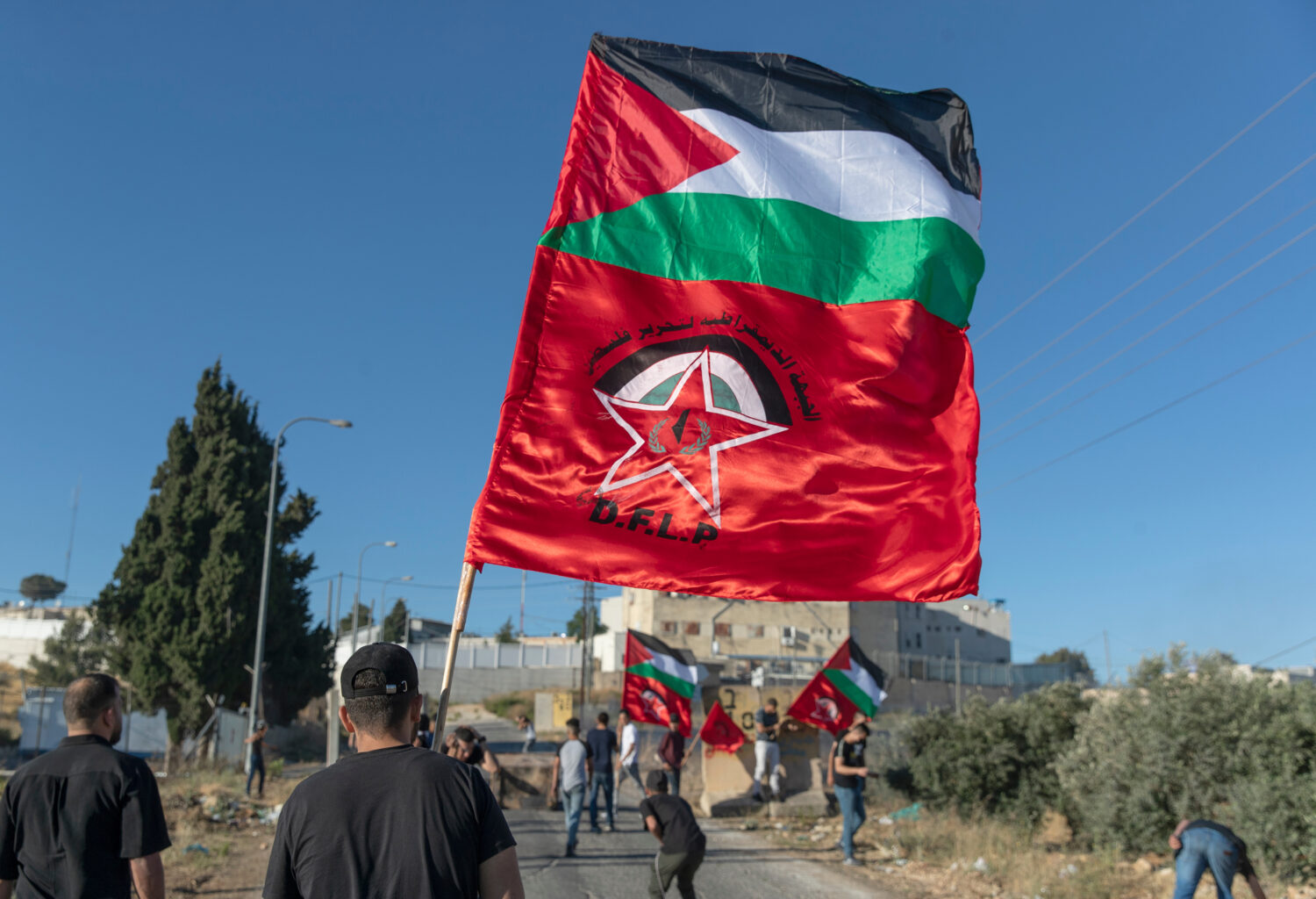 FILE - Palestinian protesters fly Palestinian flags and flags of the Democratic Front for the Liber...
