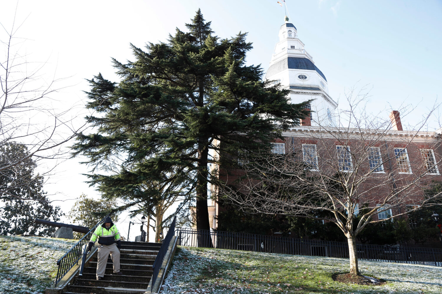 FILE - A worker blows leaves and snow off steps outside of the Maryland Statehouse on the morning o...