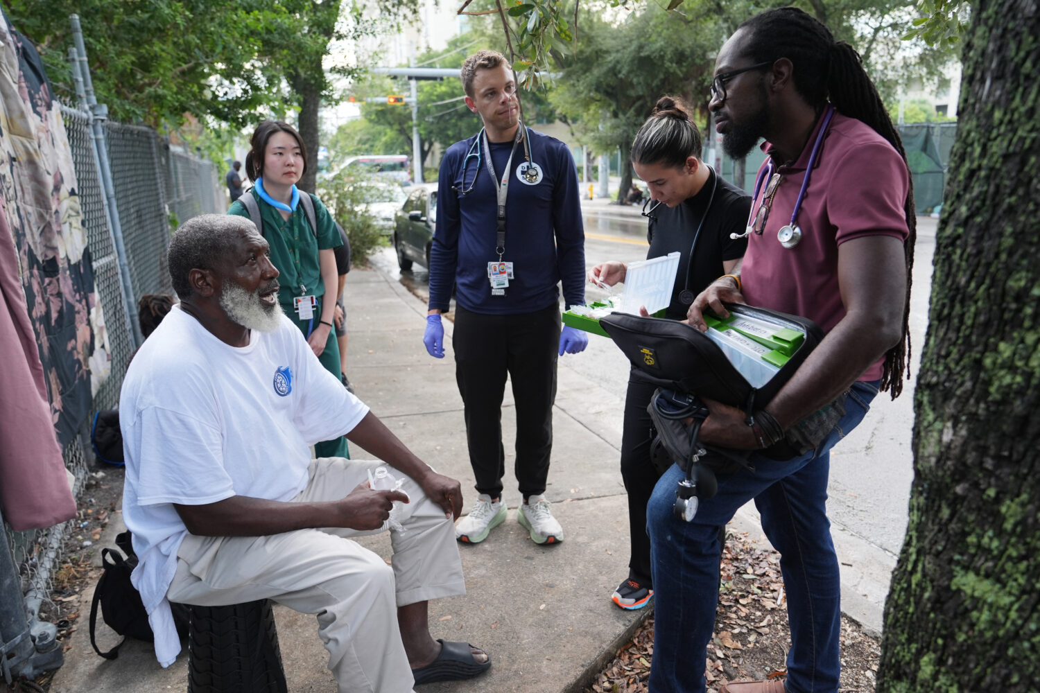 Dr. Inaki Bent, right, talks with Jonas Richards, left, while working with the Miami Street Medicin...