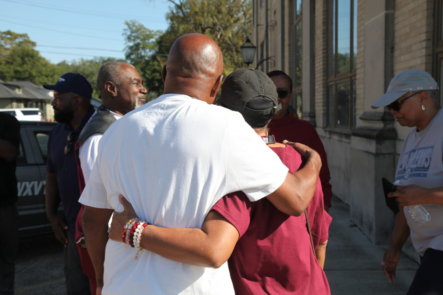 Friends and family of victims of a homecoming shooting embrace in downtown Leland, Miss., Saturday,...