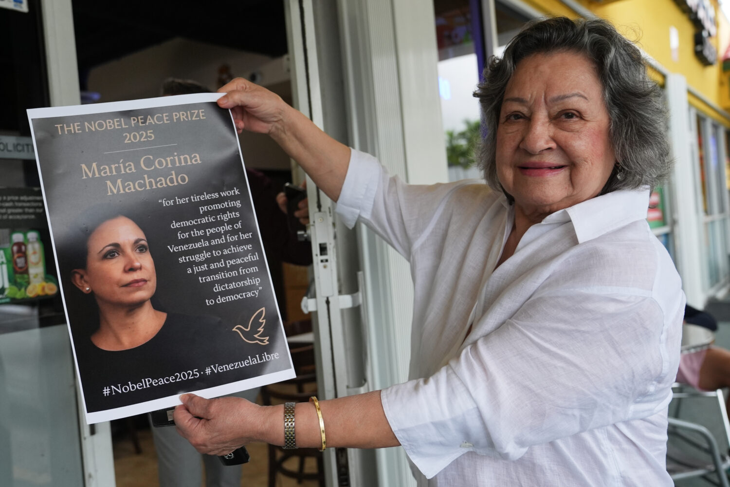 Iris Wilthew holds a poster in support of Venezuelan opposition leader Maria Corina Machado winning...