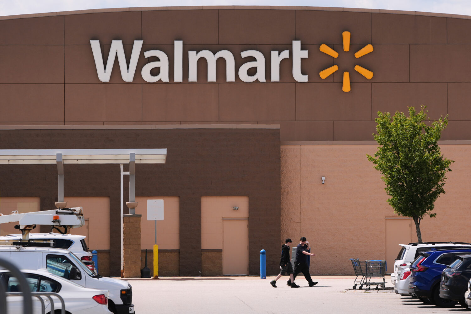FILE - Shoppers walk from the Walmart store, Aug. 14, 2025, in Manchester, N.H. (AP Photo/Charles K...