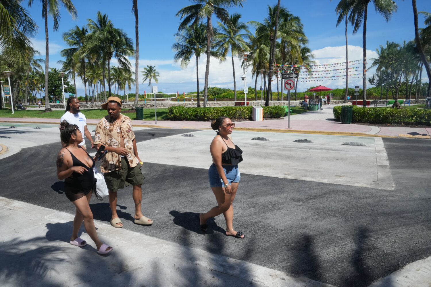 Pedestrians walk over a crosswalk on Miami Beach's iconic Ocean Drive that used to be rainbow-color...