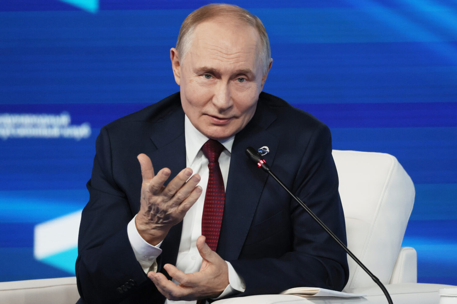 Russian President Vladimir Putin gestures as he answers questions during a meeting with foreign pol...