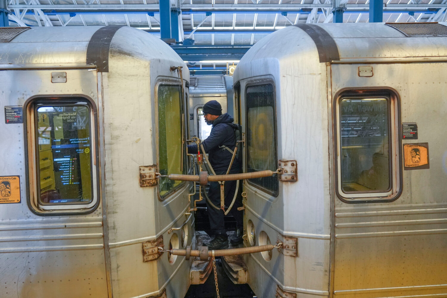FILE - A train conductor walks between subway cars at a station in the Coney Island section of New ...