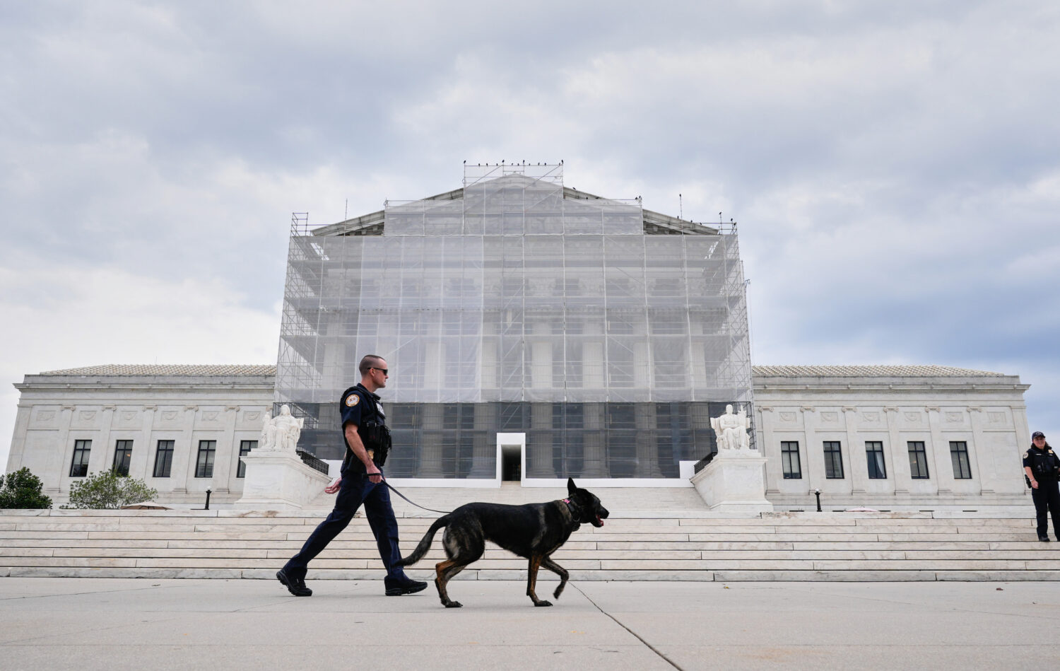 U.S. Capitol Police officers with a K9 detector dog, patrols outside of Supreme Court, Wednesday, S...