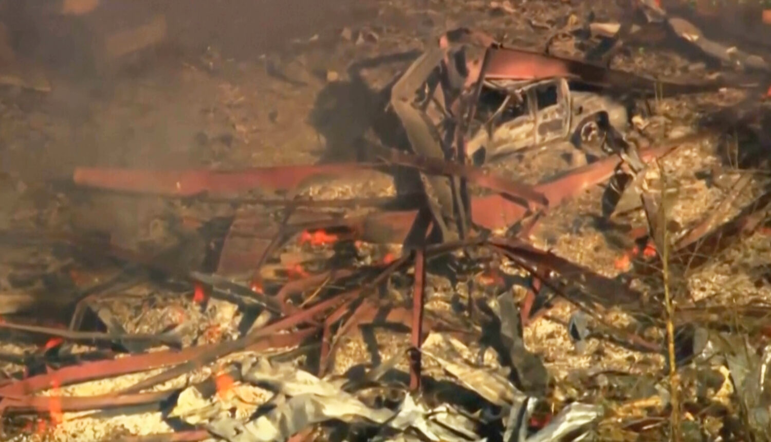 Debris covers the ground and vehicles after a powerful blast ripped through a military explosives m...