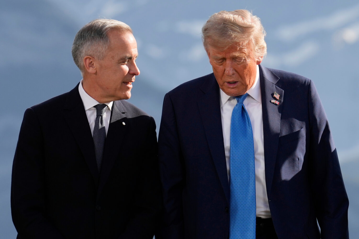 FILE - Canada's Prime Minister Mark Carney talks with President Donald Trump before a group photo a...