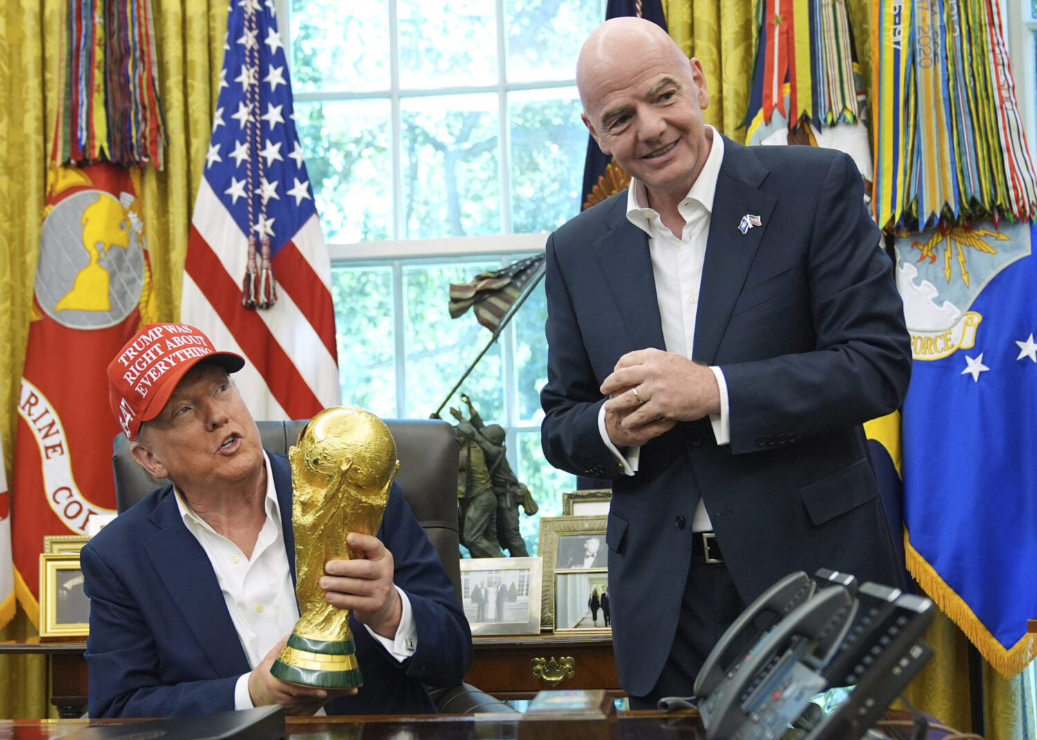 FILE - President Donald Trump holds the FIFA World Cup Winners Trophy as FIFA President Gianni Infa...