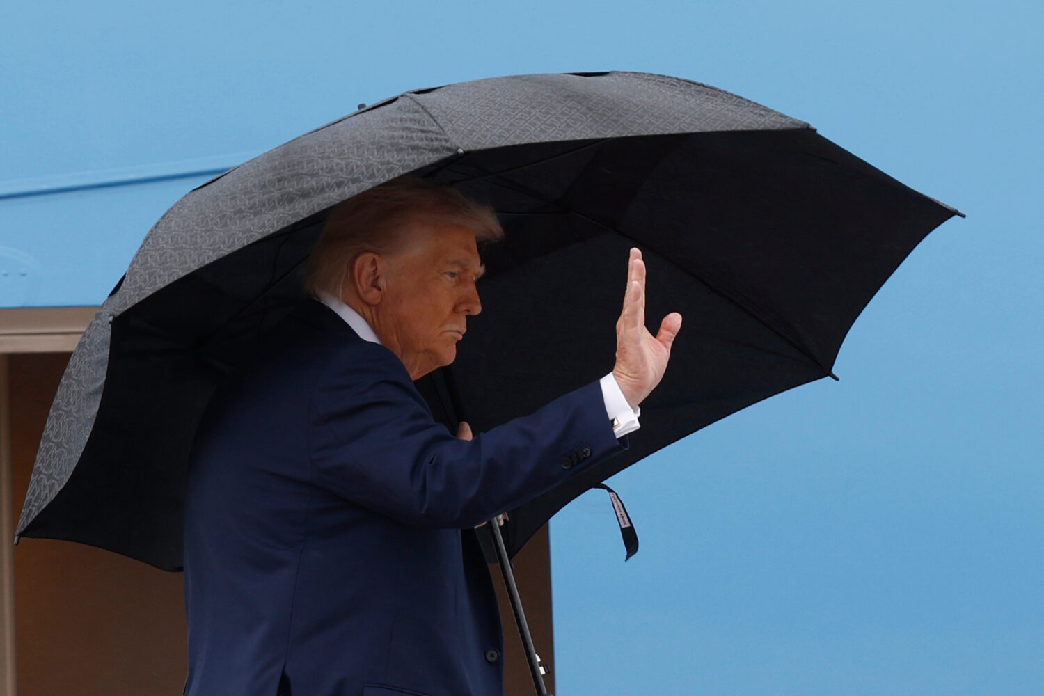 President Donald Trump waves from the stairs of Air Force One as he boards upon his arrival at Join...