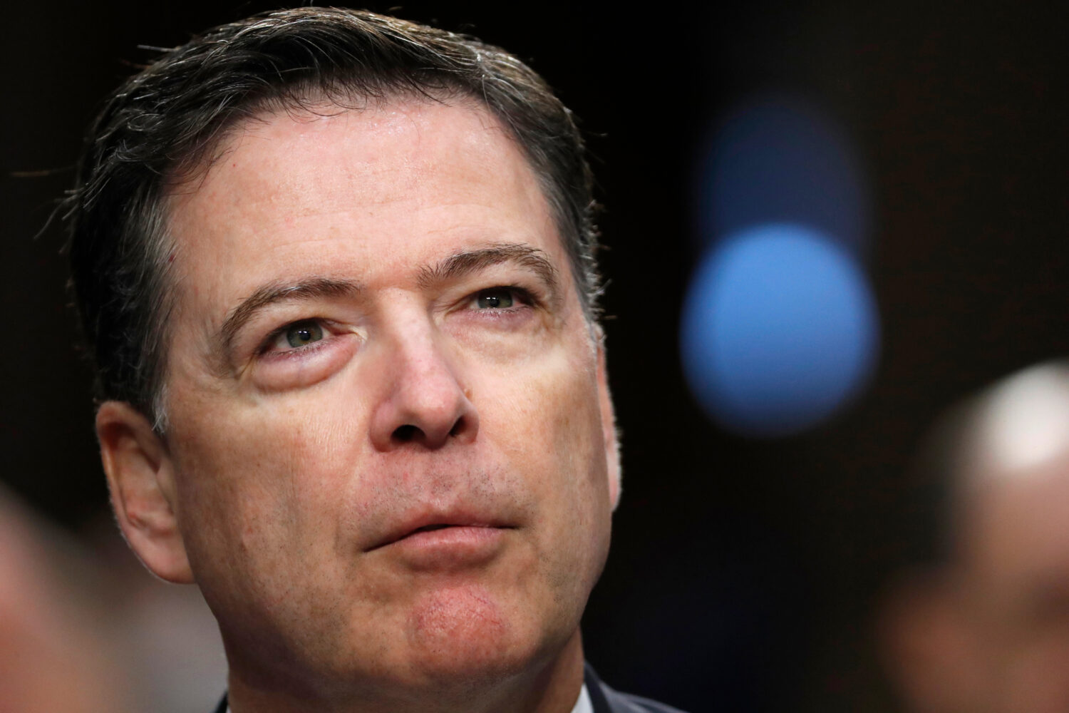 FILE - Former FBI Director James Comey pauses as he speaks during a Senate Intelligence Committee h...