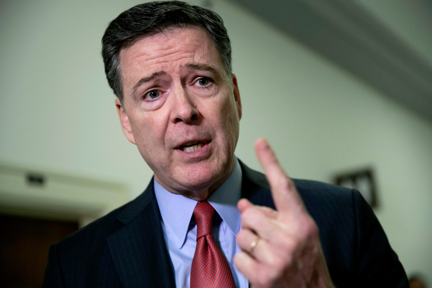 FILE - Former FBI Director James Comey speaks to reporters on Capitol Hill Washington, Dec. 17, 201...