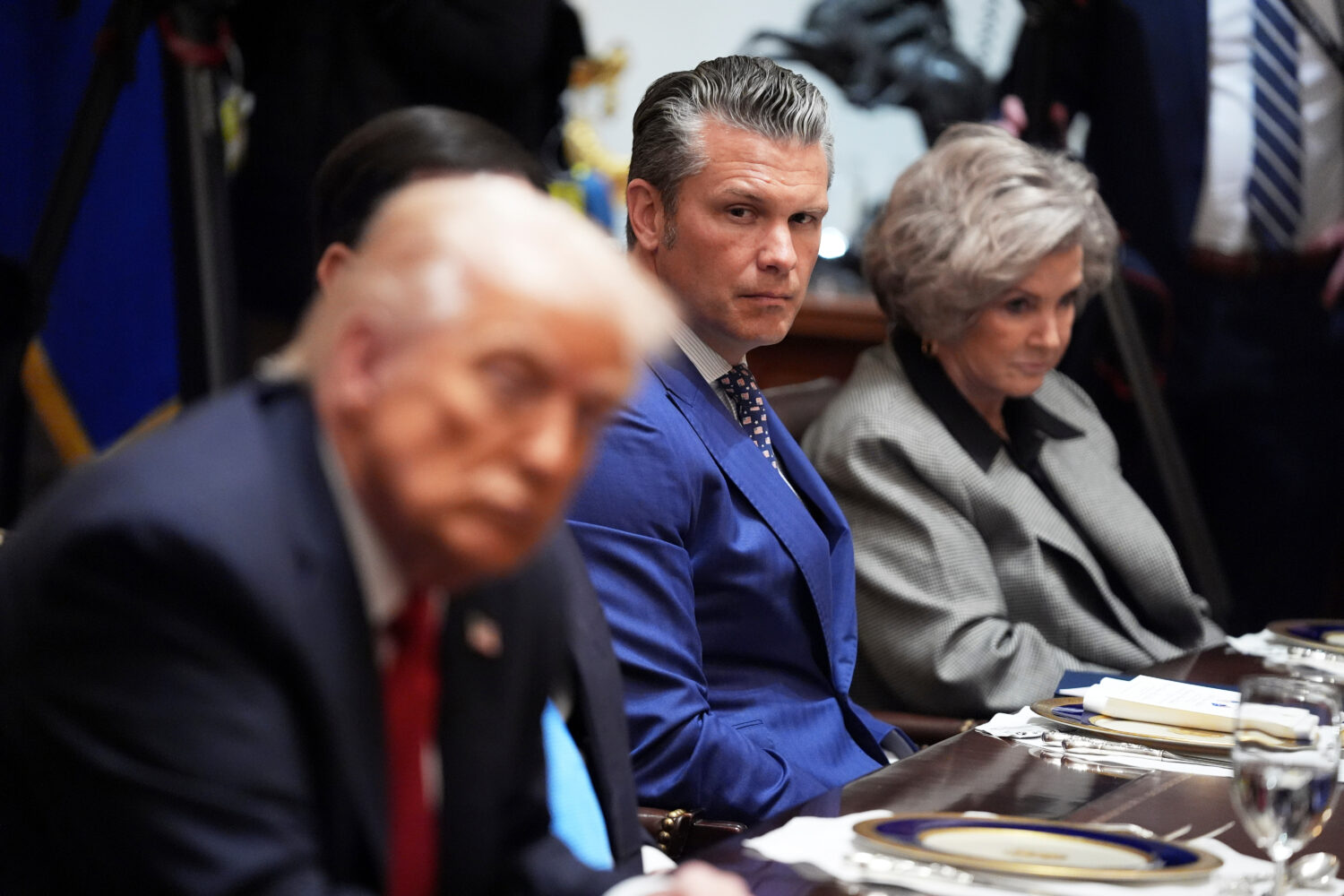 Defense Secretary Pete Hegseth listens as he and White House Chief of Staff Susie Wiles, right, lis...