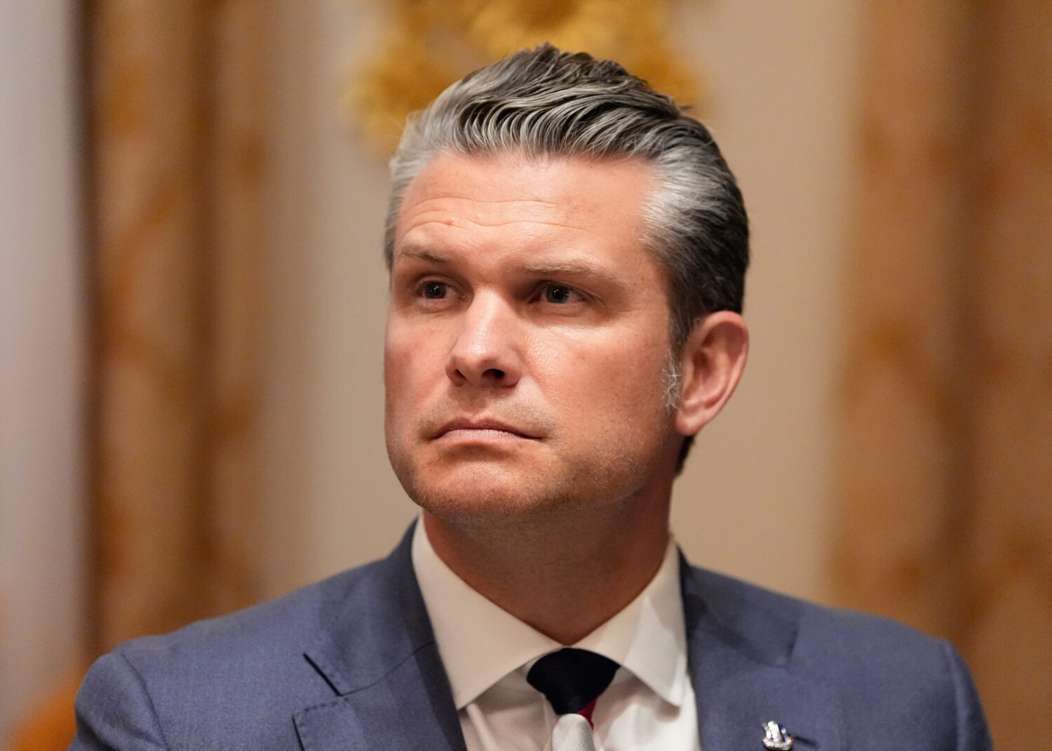 Defense Secretary Pete Hegseth listens as President Donald Trump speaks before a lunch with Ukraine...
