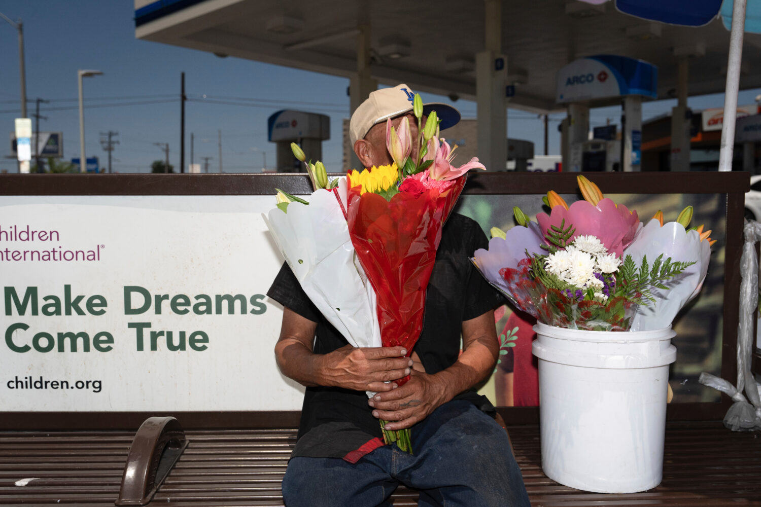 FILE - Flower vendor Jose, an immigrant from Mexico, sits for a photo with his face covered by flow...