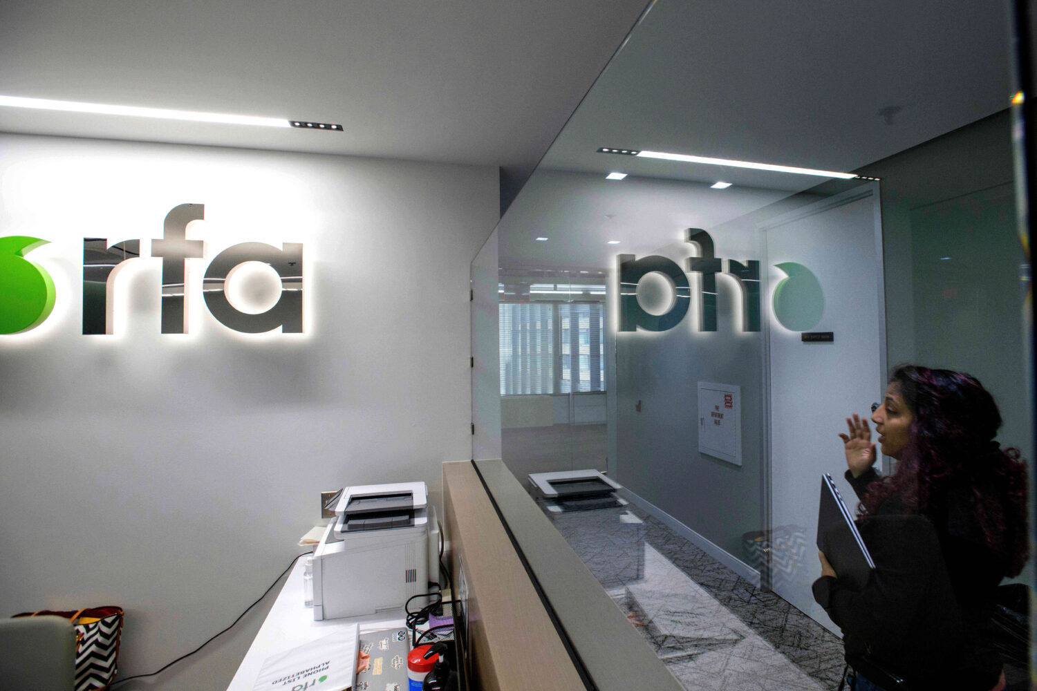 FILE - A woman walks past the empty receptionist desk at Radio Free Asia, April 1, 2025, in Washing...