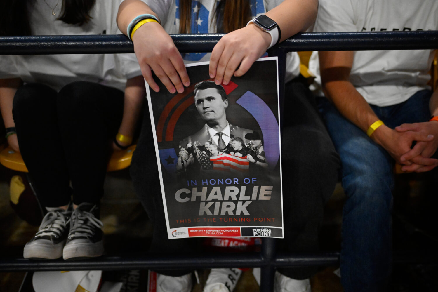 An attendee holds a poster of Charlie Kirk at a Turning Point USA rally at Utah State University, a...
