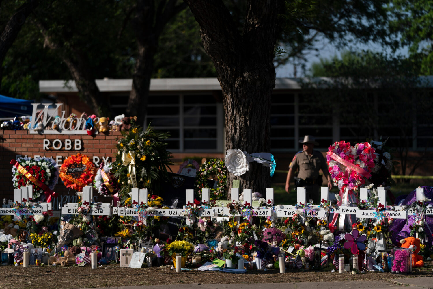 FILE - Flowers and candles are placed around crosses on May 28, 2022, at a memorial outside Robb El...