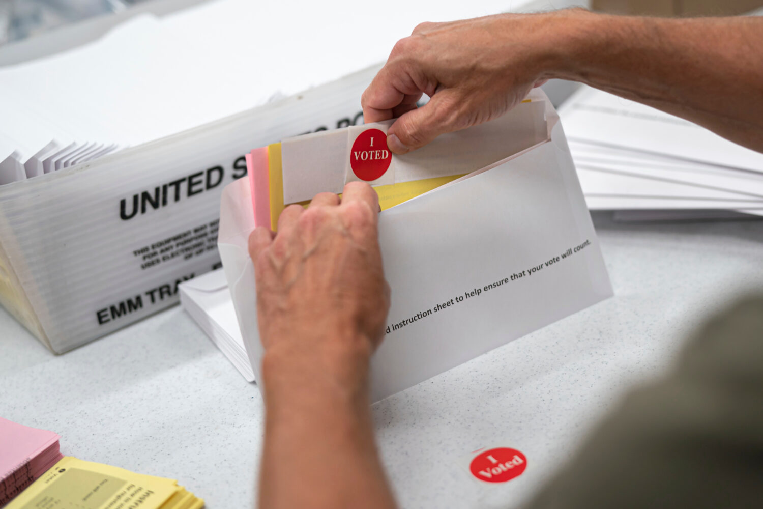 FILE - Todd Gallagher prepares mail in ballot envelopes including an I Voted sticker, July 29, 2020...