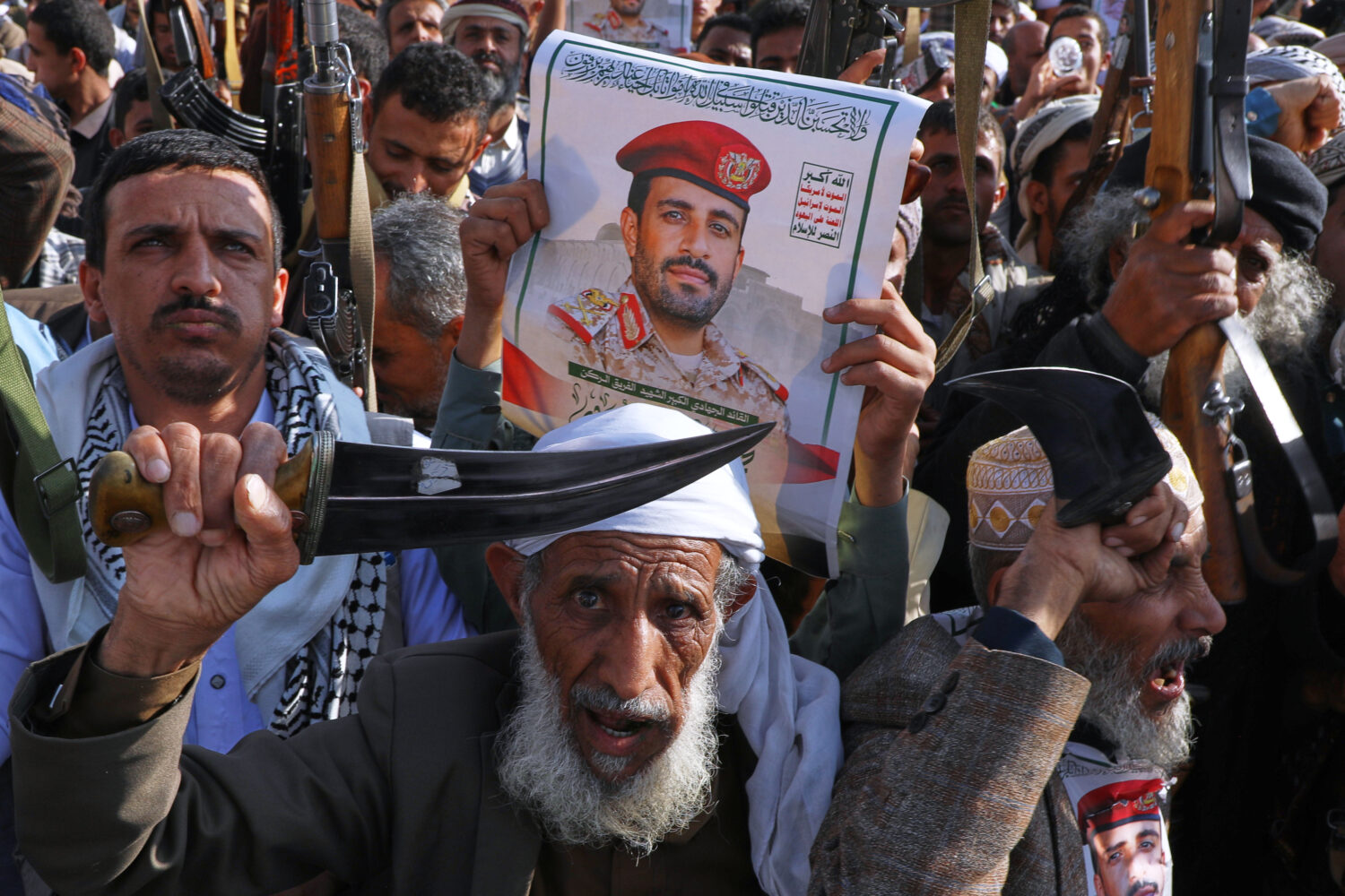 Houthi supporters hold a poster of Maj. Gen. Muhammad Abdul Karim al-Ghamari, who died of wounds he...