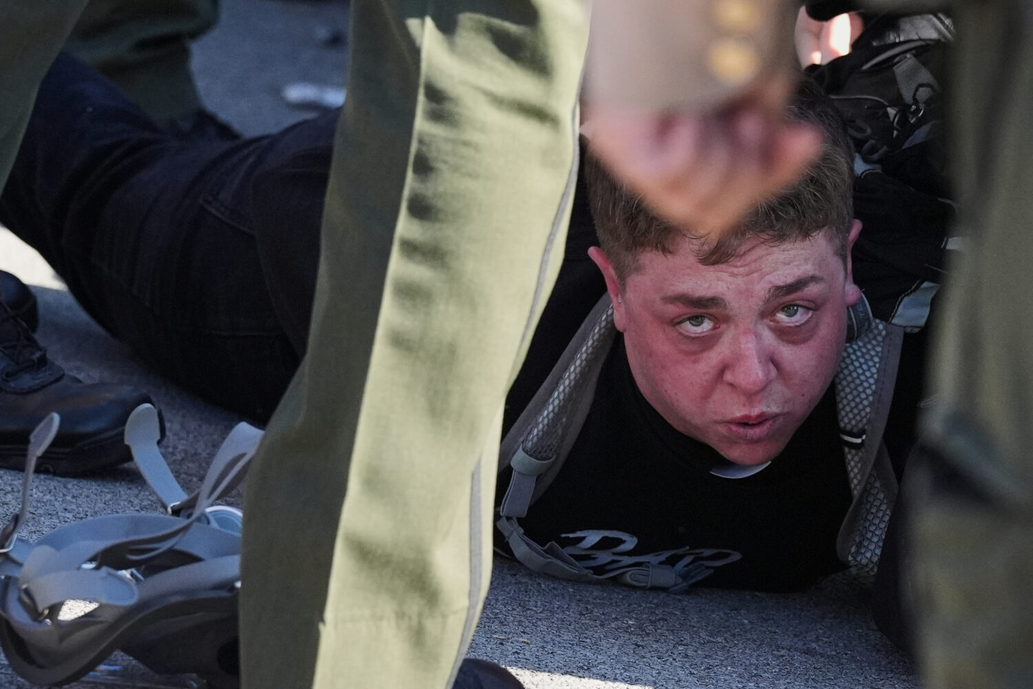 Illinois State police detain a protester outside an ICE processing facility in the Chicago suburb o...