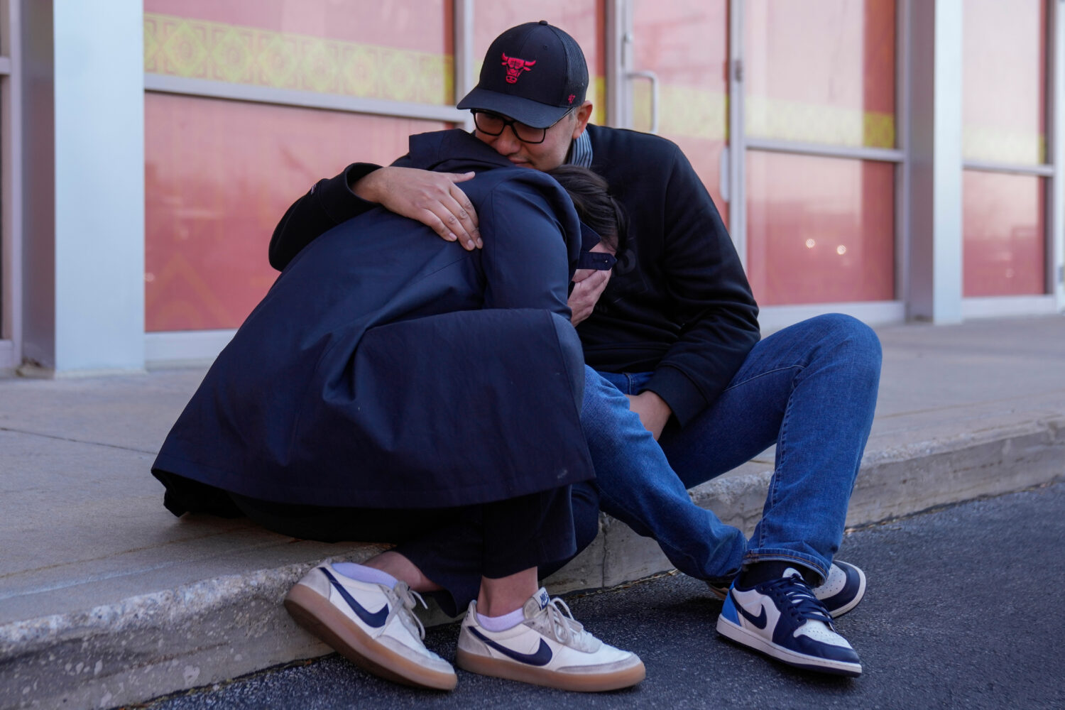 Maria Guzman, left, and Sergio Rocha, parents of young children, comfort each other outside of Rayi...